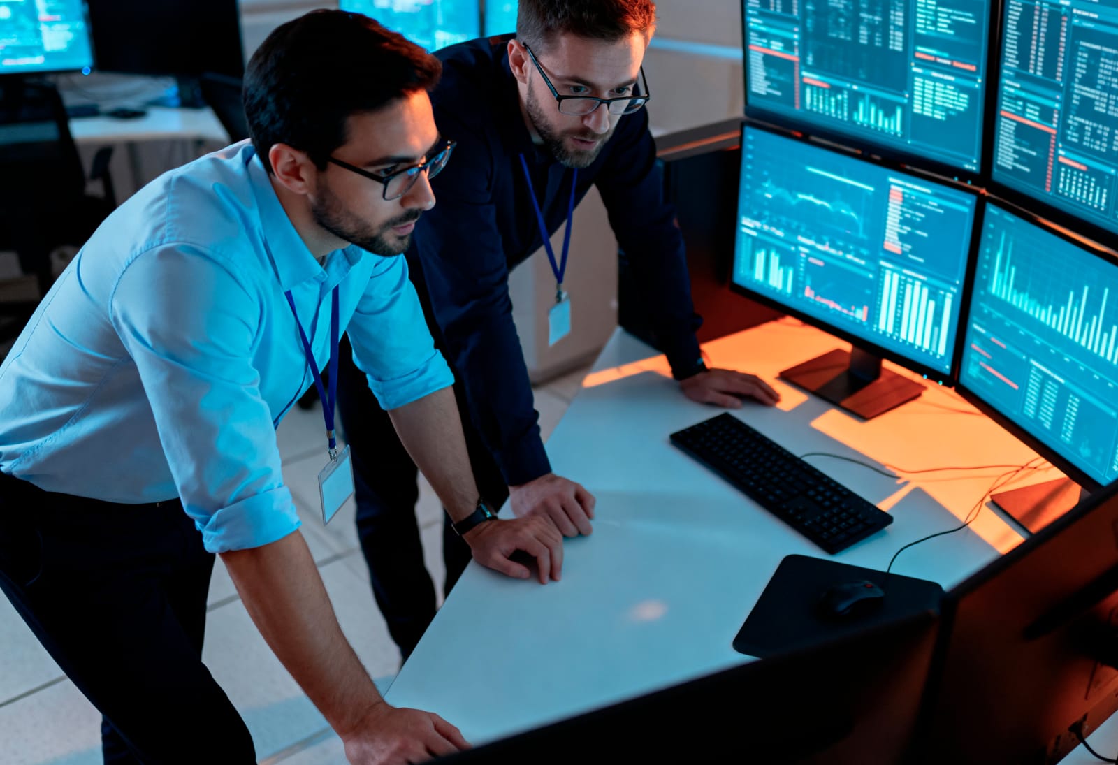 Analysts reviewing real-time system telemetry in an operations control room.